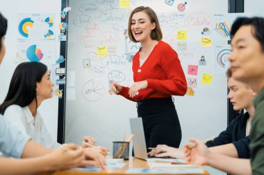 Profesyonel çekici kadın lider, modern iş toplantı odasında beyin fırtınası zihin haritalama istatistikleri ve renkli yapışkan notlar kullanarak yaratıcı pazarlama planını sunuyor. Tertemiz..