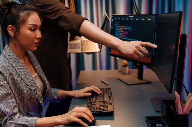 Modern ofisteki neon ışık odasında bilgi ağını gösteren dizüstü bilgisayarla iki ekranda veri çalıştıran akıllı web sitesi geliştirme kodlayıcı sistemini tartışan IT geliştiricilerinin ciddiyeti. İnfobahn.