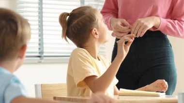 Beyaz bir çocuk ödevlerini yaparken ve açıklama dinlerken güzel bir öğretmen sınavı açıklıyor. Sınıfta not alırken ya da kağıda cevap yazarken öğretmenine bakan sevimli bir çocuk. Pedagoji.