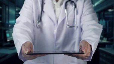 Doktorun laboratuvarda bulanık bir geçmişi olan insan anatomisi hologramı içeren tablet göndermesini kapatın. Sağlık çalışanı tableti tutuyor ve bütün gövdeyi kontrol ediyor. Teknoloji. İyileştirici.