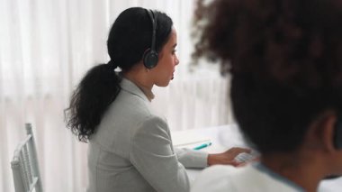 Ofiste çalışan kulaklık takan işadamları uzak müşteri ya da meslektaşlarını desteklemek için çalışıyorlar. Çağrı merkezi, tele pazarlama, müşteri destek acentesi telefon görüntülü konferans görüşmesi için hayati önem taşıyor.