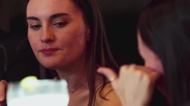 Yakından güzel bir kadın fermuarla margarita kokteylinin tadını çıkarıyor. Lezzetli bir barda arkadaşla canlı sohbetler kuruyor. Canlı bir gece kulübünde arkadaşlık kuruyor. Vinosity.