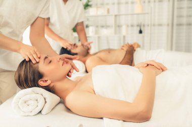 Kafkasyalı çift stres önleyici kafa masajının keyfini çıkarıyor ve lüks otellerde ya da otel spa salonlarında gündüz kaplıcalarında yüz güzelliği eğlencelerini şımartıyor. Sessiz.