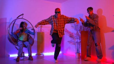 Stüdyoda gündelik kıyafetleri olan çok kültürlü bir arkadaş tezahürat yaparken mutlu hipster break dansları. Profesyonel sokak dansçısı hip hop ritmi ya da neon veya kurşun ışıkla kafiyeli bir şarkı söyler. Mutluluk.