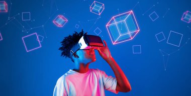 Geometrik şekillerde süzülürken mavi arka planda duran zeki çocuk. Afrikalı bir adam oyun oynuyor, VR gözlük takıyor ve sıradan bir gömlek giyiyor. Gelişmiş gerçeklik teknolojisi yenilik kavramı. Yaratıcılık.