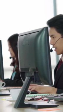 Ofiste çalışan kulaklık takan işadamları uzak müşteri ya da meslektaşlarını desteklemek için çalışıyorlar. Arama merkezi, tele pazarlama, müşteri destek acentesi telefon görüşmesinde hizmet sunar.