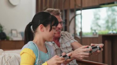 Büyükbaba ve torun birlikte konsol oyunu, eğlence medyası oynuyorlar. Eski kullanım teknolojisi yeni nesil ile iletişim kurar. Nesiller arası uçurum aile bağını güçlendirir. Uyumsuzluk.