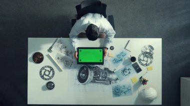 Türbin motor çizim tasarımı, metal teçhizat ve mimari ekipmanlar etrafa saçılmış yeşil ekranı incelerken kağıt üzerine yazı yazan yetenekli mühendisin üst görünümü. Hizalama.