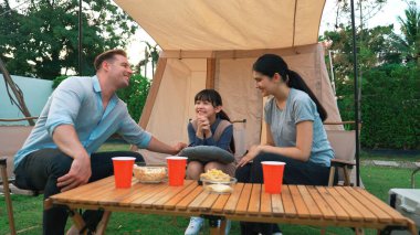 Family all together sit at camp in garden with tasty snack. Lovely parent use outdoor camping activity as way to communicate and spending time with young generation cross generation gap. Divergence. clipart