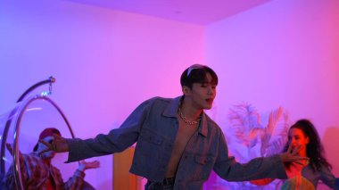 Çok kültürlü bir arkadaş kürsüde otururken Asyalı yetenekli bir dansçı modern müziğe geçiyor. Profesyonel dansçı, hipster takımı tezahürat yaparken ve desteklerken enerjik adımlar atıyor. Mutluluk.