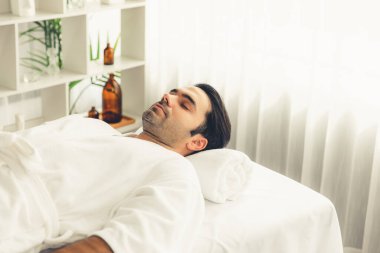 Kafkas erkek müşteri stres önleyici spa masajının keyfini çıkarıyor ve lüks otel veya oteldeki gündüz açık hava ortamında güzellik derisi eğlencesi ile şımartıyor. Sessiz.