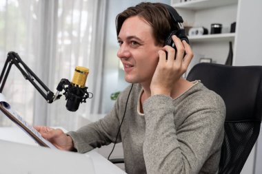 Akıllı yayıncının sunucu kanalı canlı sosyal medya yayını ile dinleyicilere senaryo okuyarak, kulaklık takarak modern ev stüdyosundaki video flamalarını kaydediyor. Bireysel.