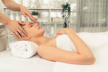 Kafkasyalı kadın stres önleyici kafa masajından ve lüks tatil beldesi ya da otel spa salonundaki modern ışık ortamında yüz güzelliği eğlencelerini şımartmaktan hoşlanıyor. Sessiz.