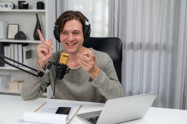 Sunucu kanalı, gülümseyen akıllı yayıncı kaydı, senaryosu ve akıllı telefonuyla sosyal medyada sohbet programı, kulaklık takarak modern ev stüdyosundaki video flamalarını kaydediyor. Bireysel.