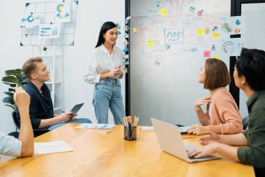 Genç ve güzel lider pazarlama stratejisini sunarken, uzman yatırımcı ve proje yöneticisi de yeni başlayan iş toplantısında iş performansını analiz etmeye çalışıyor. Çok ırklı bir grup. Tertemiz..