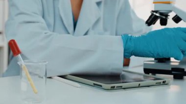 Laboratuvar kimya araştırmacısı mikroskop kullanarak yeni ilaç ya da tedavi geliştirir. Laboratuvar mikrobiyoloji ekipmanları ile bilimsel uzmanlık ile sağlık hizmetlerinin teknolojik gelişimi. Ağır çekim. Katı.
