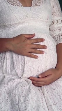 Hamile bir kadın çocuğuna bakarken kendini mutlu hissediyor. Hamile karnında bebek taşıyan hamile bir anne. Doğum öncesi bakım ve kadın hamileliği konsepti.