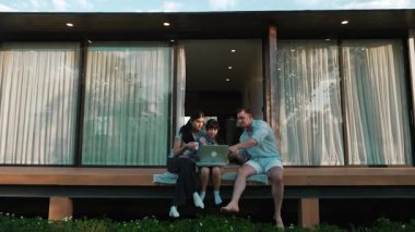 Şirin baba, anne ve kızı birlikte evin bahçesinde oturuyorlar. Ebeveynler, çevre farkındalığıyla ilgili genç nesli iletişim kurmak için açık hava aktivitelerini kullanırlar. Uyumsuzluk.