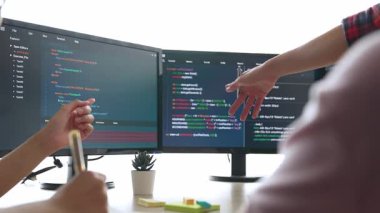 Yavaş çekim arkası yazılım geliştirici mühendisi bilgisayar programlama için birlikte çalışarak hata ayıklama kodunu çözüyor, ofiste monitörde karmaşık algoritmaları çözüyor. Filizlenen
