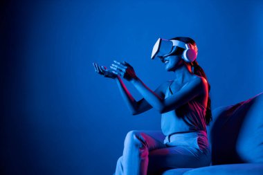 Kanepede oturan zeki kadın, neon ışıklı kulaklık takıyor metazik, fütüristik siber uzay topluluğu teknolojisini birbirine bağlıyor, elle sanal nesneyi izliyor ve onunla etkileşime geçiyor. Halüsinasyon.