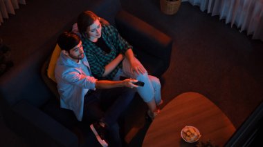 Babamın elinde uzaktan kumandayla kanal değiştirirken, anne ve babanın birlikte televizyon izlediği mutlu beyaz adam manzarası. Akıllı aile film hakkında konuşmaktan zevk alırken birlikte vakit geçirir. Cemaat.