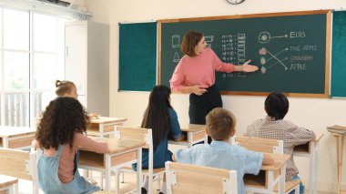 Zeki öğretmen sınıfta fikri açıklarken sevimli öğrenci ödevlerini kontrol ediyor. Not defterine bakıp matematik teorisinden çocuğa bahsederken sınıfta dolaşan çekici bir eğitmen. Pedagoji.