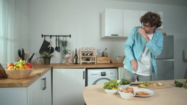 Mutlu baba yemek pişirirken müziğe geçiyor ve modern mutfakta öğle yemeği hazırlıyor. Aktif baba, sebze ve mutfak gereçleri ile çevrili sağlıklı yemek ya da salata yaparken şarkıyla dans ediyor. Pedagoji.