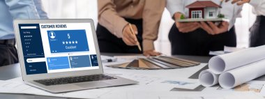 İç mimar tasarımcı grubu, daha kesin tasarım için planlar ve dizüstü bilgisayar ekran mimari yazılımı üzerinde birlikte tartışıyorlar. Modern ev tasarımı ve yenileme. İçgörü