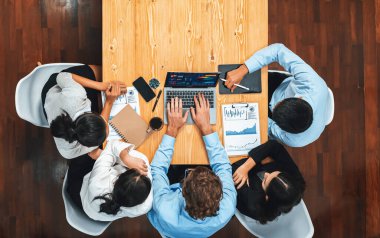 Panorama üst düzey iş analist grubu toplantı masasındaki finansal veri raporunu analiz ediyor. İş zekası analizine göre çizelge ve grafik paneli. Çok titiz.