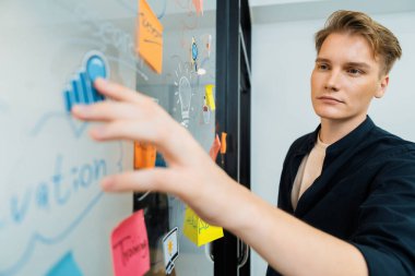 Kafkasyalı profesyonel iş adamının zihin haritası ve renkli yapışkan notlar kullanarak iş pazarlama fikrini kendine güvenle sunuşunun yakın görüntüsü. Proje konseptini başlat. Portre. Tertemiz..