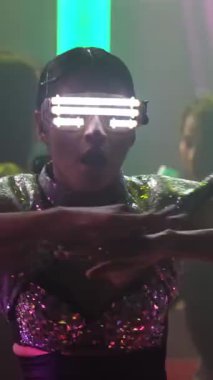 Bir grup insan disko gece kulübünde DJ 'in sahnede çaldığı müzikle dans ediyor. Yeni yıl partisi ve gece hayatı konsepti .