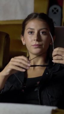 Sinemada üç boyutlu gözlüklü bir kadın ve erkek film izliyor. Ekrana bakar, heyecan verici ve patlamış mısır yer.