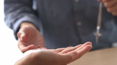 Yavaş çekimde kutsal haçı diğerine teslim etmek Katolik inancı dönüşümünün bir göstergesidir. Hristiyan takipçi diğerini dönüştürüyor. Aşkın ve fedakârlığın sembolü olarak haç ve İncil 'i veriyor. Filizlenen