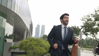 Keyifle dans eden yetenekli beyaz iş adamı soğukkanlılığını koru ve şehir merkezinde yürümeye devam et. Profesyonel menajer terfi ile ilgili iyi haberleri kutlamak için dans ediyor. Sevinçli..