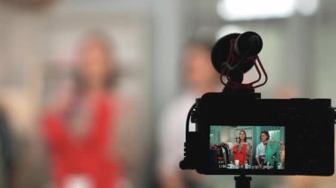 Arka görünüm, kamera ekranının arkasında iki kadın nüfuzlu görüntüleyicinin video görüntülerini, video görüntülerini, kıyafetleri, sosyal medyayı ya da blogu görüntülemesini gizler. Canlı yayın için stüdyo ışıklandırmalı kızlar canlı yayın pazarlama kayıt oturumu