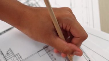 Ölçüm aracı ve kalem el kullanan akıllı mimar veya akıllı mühendisin videosu mimari ofisteki inşaat hatasızlığı için ayrıntılı bir tasarım hazırladı. Eline odaklan. - Yakın çekim. Tanımlama.