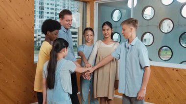 Kafkas öğretmeni ve çeşitli çocuklar sınıfta ayakta dururken başarılı projeyi kutlamak için el ele tutuşuyorlar. Aşkı, takım çalışmasını, güveni, birlikteliği ve birliği temsil et. Öğretim