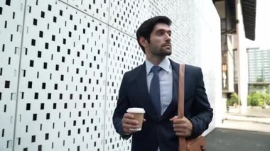 İş adamı telefona cevap verir ve iş yatırımları hakkında konuşur. İş planı, pazarlama stratejisi ya da çalışma hakkında konuşmak için akıllı telefonla konuşurken sokakta yürüyen mutlu bir yönetici. Sevinçli..