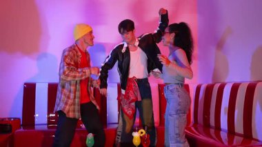 Çok kültürlü bir arkadaş birlikte dans ediyor ve hiphop müziği eşliğinde restoranda ya da kafede pembe neon ışıklı duruyor. Profesyonel sokak dansçıları grubu enerjik hareketler sergiliyor. Mutluluk.