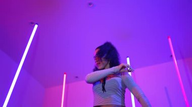 Latin dansçıların kameraya bakıp şehrin pop müziğiyle dans ettiği düşük açılı kamera. Profesyonel çekici hipster, mor veya neon ışıklı hip hop şarkısına geçiyor. Şık bir kumaş. Mutluluk.