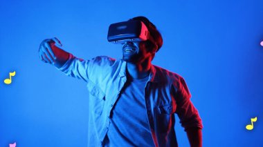 Mutlu dansçı VR gözlük takıyor ve havada süzülen notalarla şarkıya geçiyor. Dans ederken ve hareketli adımlar atarken sanal gerçeklik kulaklığı kullanan çekici bir adam. Aygıt.
