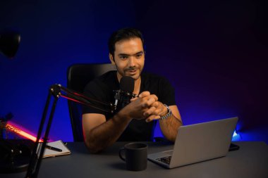 Yayıncı, fanclub dinleyicisiyle mikrofon kullanarak konuşuyor. Mor neon ışıklı modern stüdyoda yaratıcı olumlu düşünce konseptiyle canlı yayında finansal sorunları tartışıyor. Tahmin et..