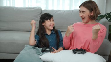 Mutlu çocuk oyun oynuyor ve oturma odasında otururken annesini kazanıyor. Çekici kız elini havaya kaldırıp şarapları kutlarken beyaz bir anneyle vakit geçiriyor. Pedagoji.