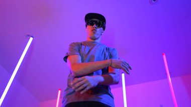 Beyaz dansçının gösterişli gözlükler taktığı ve break dans yaptığı alçak açılı kamera. Çekici adam kendinden emin bir şekilde kameraya bakarken enerjik bir performans ve hareket gösterdi. Mutluluk.