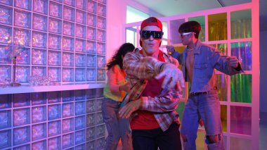 Değişik takımlarla dans ederken süslü gözlük takan yakışıklı hippi serbest stil müzikle mutlulukla dans ediyor. Beyaz hipster kulüpte parlak neon ışıkta sokak dansı yapıyor. Mutluluk.