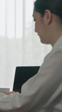 Ofis çalışma alanında birlikte çalışan iki genç hevesli iş kadını. Genç meslektaşlar tartışırken ve dizüstü bilgisayar kullanırken. Modern ofis çalışanları masada birlikte oturuyorlar..