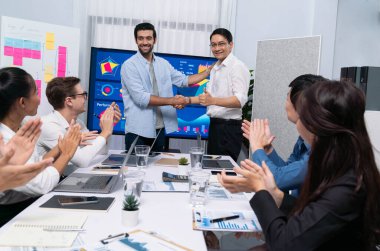 Analist ekip lideri, iş zekası ya da BI gösterge paneli ile FIntech yazılım gücünü kullanarak başarılı veri analizi toplantısından sonra iş arkadaşıyla tokalaştı. Tedbirli