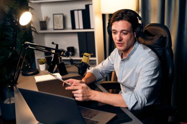 Akıllı yayıncının sunucu kanalı, canlı sosyal medyada canlı yayında konuşma programı ile birlikte modern stüdyoda, kayıt cihazıyla dinleyiciye senaryo okumaktadır. Bireysel.