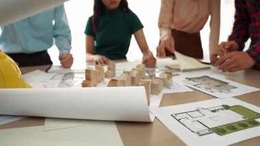 Mimari döküman, ölçüm araçları ve ahşap blokların modern ofiste etrafa saçıldığı masa üzerine planlar yapma konusunda akıllı mimar ve güvenlik mühendisi tartışması. - Yakın çekim. Tanımlama.