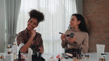 İki kadın nüfuzlu kişi canlı yayında video görüntülerini çekiyor. Makyaj çok önemli sosyal medya veya blog. Kozmetik stüdyosu ışıklandırmalı mutlu genç kız çevrimiçi pazarlama oturumu yayını için..